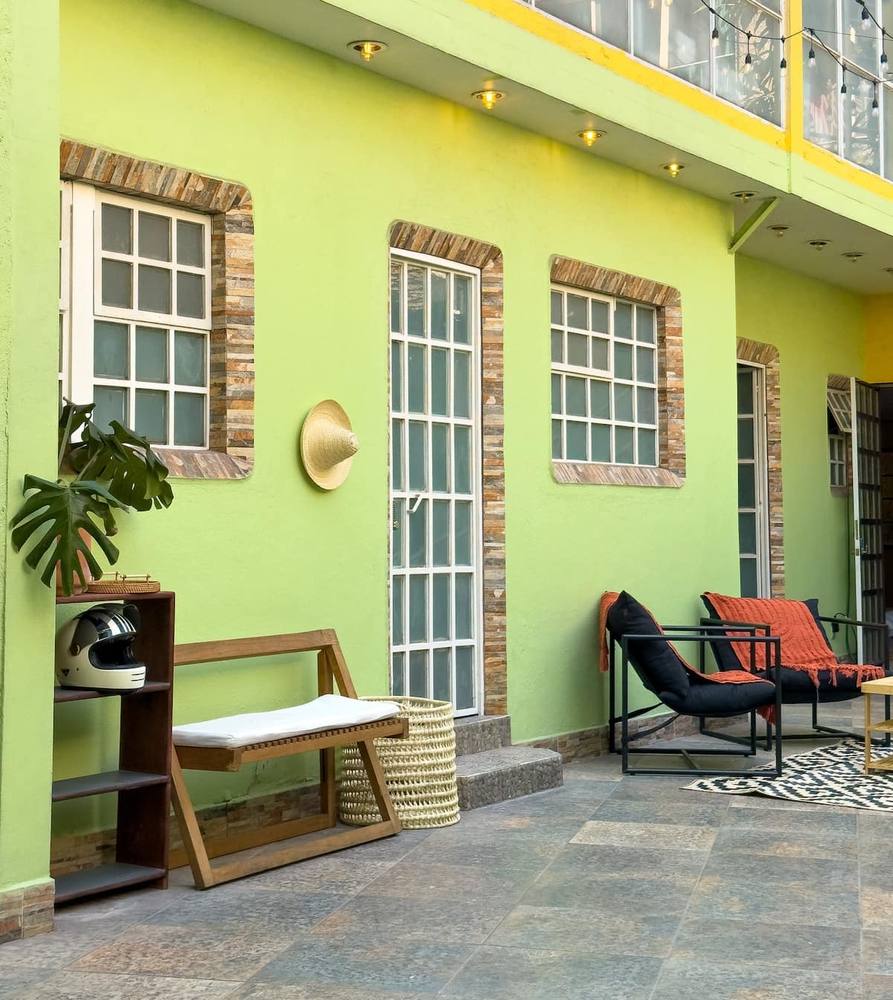 Patio · muro verde, ladrillo y ventanales