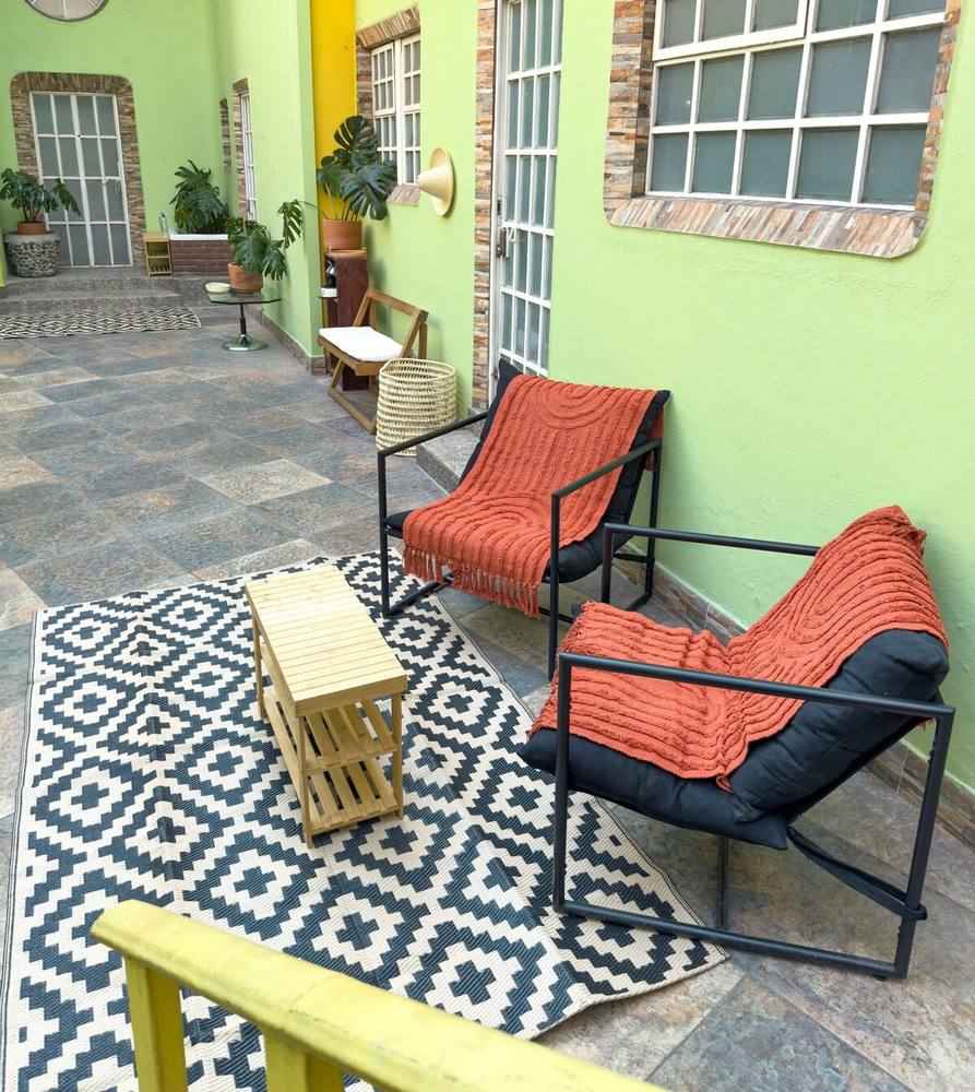 Patio · zona de sillas y banca amarilla
