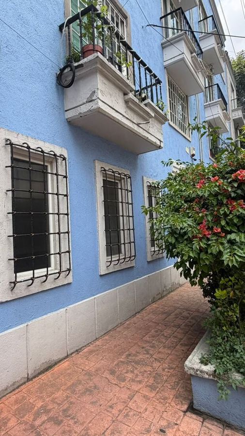 Edificio azul, balcones y buganvilias