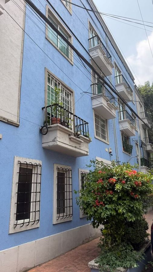 Edificio azul, balcones y buganvilias