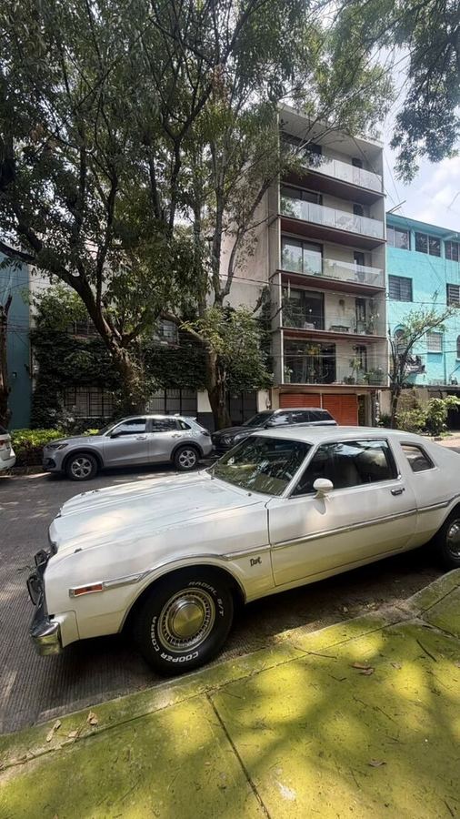 Escena de calle, auto clásico y fachadas de color